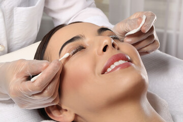 Young woman undergoing eyelash lamination in salon, closeup - obrazy, fototapety, plakaty