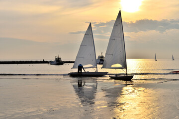 Obraz na płótnie Canvas 夕陽に染まる材木座海岸に停泊するヨット