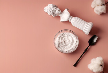 Hydrolyzed collagen in a glass cup and black spoon on a pink background. Health concept. Natural anti-aging supplement for beauty spa treatments. Copy space