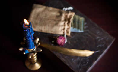 A fortune teller, witch stuff on a table, candles and fortune-telling objects. The concept of divination, astrology and esotericism