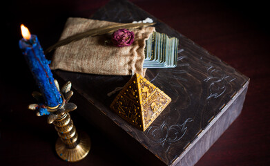A fortune teller, witch stuff on a table, candles and fortune-telling objects. The concept of divination, astrology and esotericism