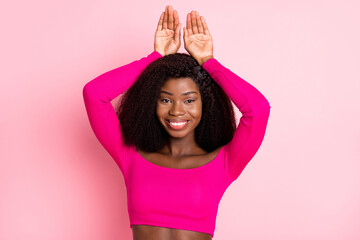 Photo of cheerful positive rabbit lady hands ears toothy smile wear singlet isolated pink background