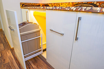 Kitchen interior design sliding cupboard detail with rubbish bin