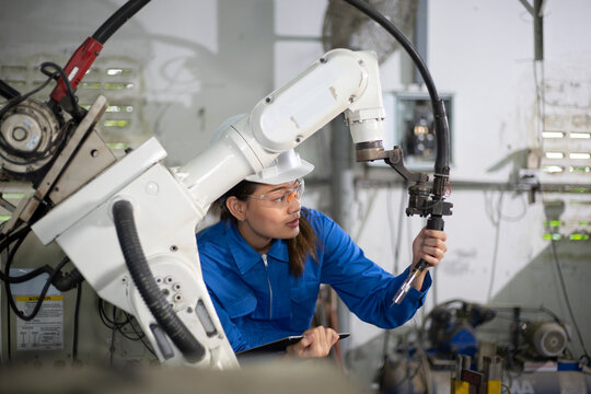 Woman mechanic repairing a robot machine.