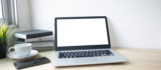 Fototapeta premium Laptop computer with white blank screen on wood desk. Workspace, workplace, desktop office concept.