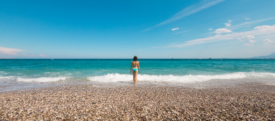 A girl in a swimsuit is resting on the sea coast