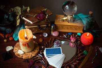 A fortune teller, witch stuff on a table, candles and fortune-telling objects. The concept of divination, astrology and esotericism