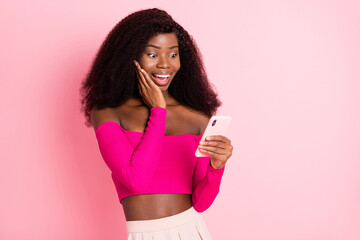 Photo of excited crazy lady hold phone palm cheek wear top unclothed shoulders isolated pink color background