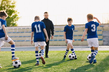School Boys with Young Sports Coach on Training. Kids Practicing Soccer on Summer Sunny Day.