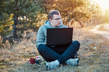 Self isolation, distractions at home concept. Unplugging after work, working too much concept. Men outside on nature with notebook is working. .