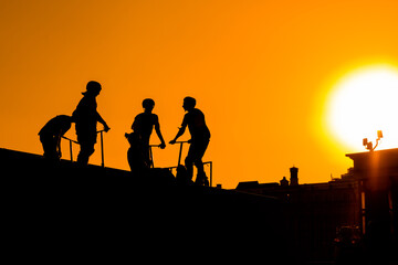 Fototapeta na wymiar Unrecognizable group of teenage boy silhouettes with scooters standing together against orange sunset sky at skatepark. Sport, extreme, freestyle, outdoor activity concept