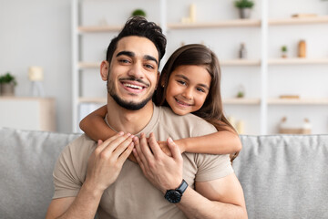 Portrait of father and daughter hugging at home