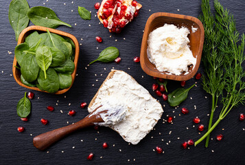 healthy sandwich - ripe pomegranate grains, young spinach leaves, aromatic dill and fresh cream