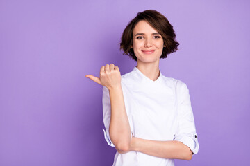 Photo of positive young happy woman point finger thumb empty space sale isolated on violet color...