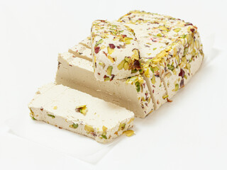 Halva with pistachios on white paper and background
