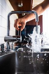 Fototapeta Running and splashing fresh water from kitchen faucet filling glass obraz