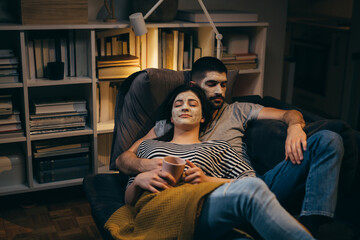couple relaxing at home with cosmetic face mask applied on faces