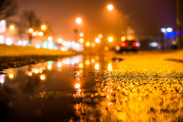 Foggy night in the big city, the street lighting lanterns and riding car. Close up view from the...