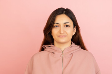 Young woman's portrait on pink studio background. Concept of human emotions, facial expression, youth, sales, ad.