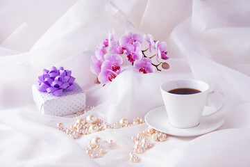 Obraz na płótnie Canvas プレゼントとコチョウランの花束とパールとコーヒー（オーガンジー背景）