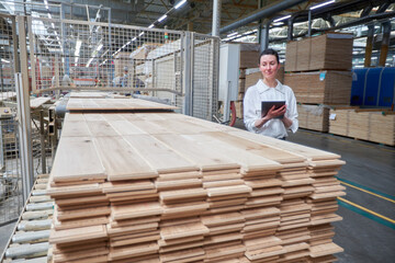 Fototapeta premium Business woman portrait in the carpentry factory using tablet pc. Carpentry factory. Factory for the production of parquet board