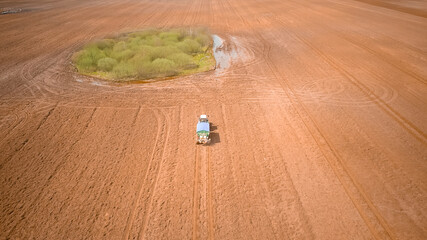 Photo from a tractor drone sowing seeds in a field. Process of planting seeds in the ground as part of an early spring agricultural activity