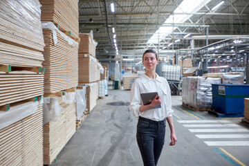 Business woman portrait in the carpentry factory using tablet pc. Carpentry factory. Factory for the production of parquet board