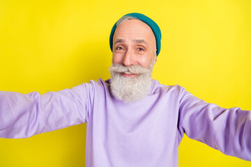 Fototapeta na wymiar Photo portrait of elder cheerful man taking selfie smiling isolated on bright yellow color background
