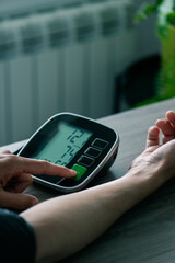 man measures his blood pressure