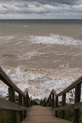Holzbrücke zum Meer bei Sturm mit Wellen