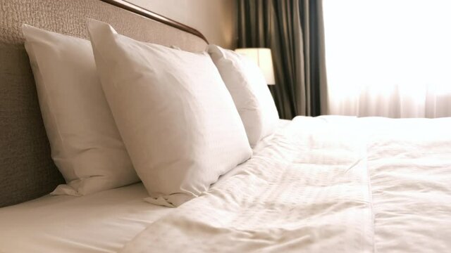 Woman hand touches the bed sheet in hotel room. Room service.