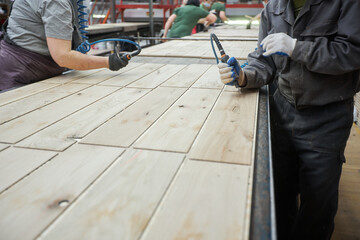 Carpenters working on wood factory with machines. Wooden furniture manufacturing process. Carpentry workshop location.