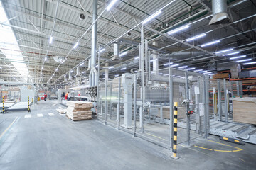 Obraz premium Carpentry factory. Automated equipment for laminate production. Modern robotic factory indoors. Woodworking production