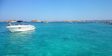 Fototapeta na wymiar emerald sea with rocky panorama and boats sardinia