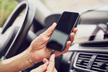 Close up girl charging phone in car