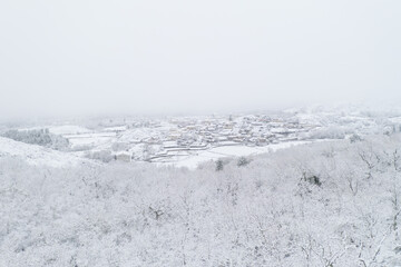 Fototapeta na wymiar Drone aerial view of a road and remote village covered with snow in the North of Portugal, Vila Real
