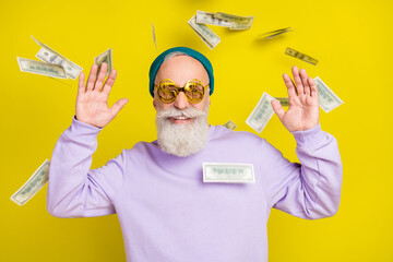 Photo of pretty funky mature man dressed purple pullover headwear eyewear flying money isolated...