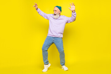 Fototapeta na wymiar Photo of sweet handsome mature man dressed purple pullover headwear dancing smiling isolated yellow color background