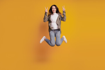 Fototapeta na wymiar Full size photo of young cheerful woman jump show v-sign isolated on yellow background