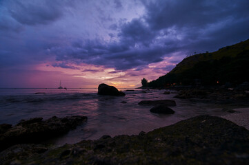 Beautiful landscape with colorful sunset on the sea rock beach.