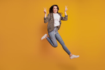 Fototapeta na wymiar Full size photo of young positive woman jump show v-sign isolated on yellow background