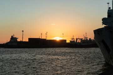 Sunset behind containers on a loading dock at the port.