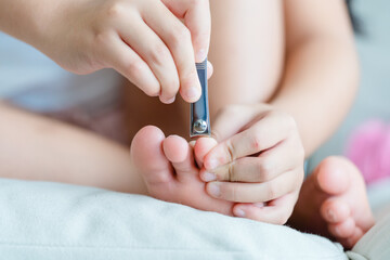 clean nails.kid child girl cutting nails using stainless steel nail clipper at home.Hygiene.virus bacteria in nails.Toe nail cutting with a cutter.sanitizer hand.coronavirus covid19.skin care.