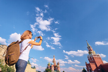 Travel and technology. Young woman taking photo on her smartphone on Red Square in Moscow, Russia.