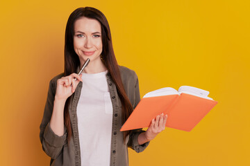 Photo of focused creative girl write copybook isolated over yellow background