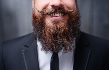 Funny beard and mustache. Close-up of young bearded man showing tongue.