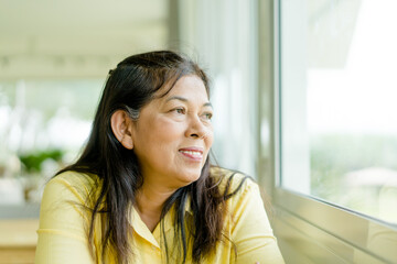 Portrait of senior woman.Senior Adult Women Smiling Happy.Hope with indian mother woman at home.60 years old women.Grandmother grandparent.Kind face looking window.mother day.retirement, alzheimer.