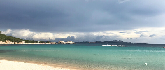 baja sardinia beach with dramatic sky