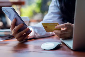Woman hand using laptop Mockup and credit card for shopping payment online at home.E-commerce and online shopping concept,