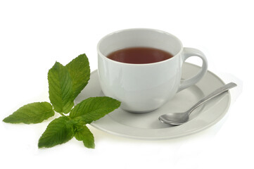 Tasse de thé à la menthe avec une cuillère et des feuilles de menthe sur fond blanc